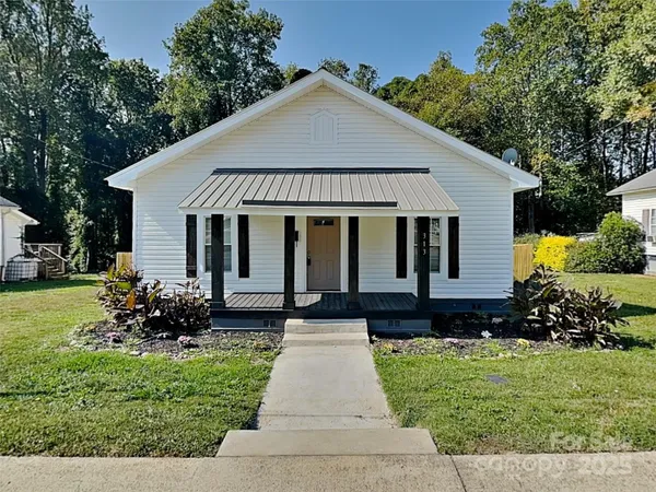 a front view of a house with a garden and plants