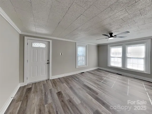 a view of an empty room and window and wooden floor