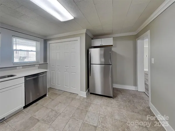 a kitchen with a refrigerator and a stove top oven