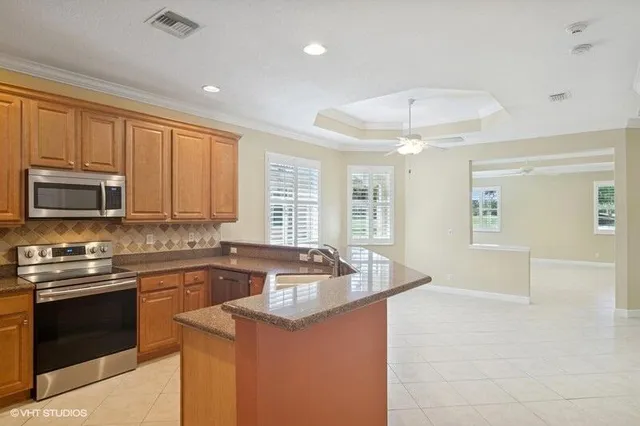 a view of kitchen with kitchen island stainless steel appliances sink and microwave