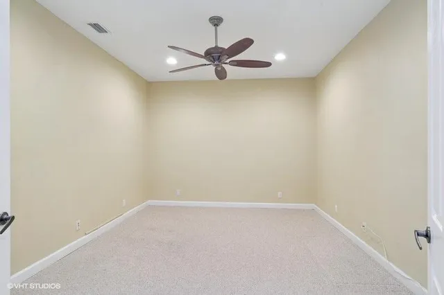 an empty room with closet and a chandelier fan