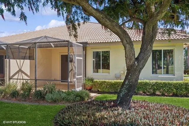 front view of house with a yard and potted plants