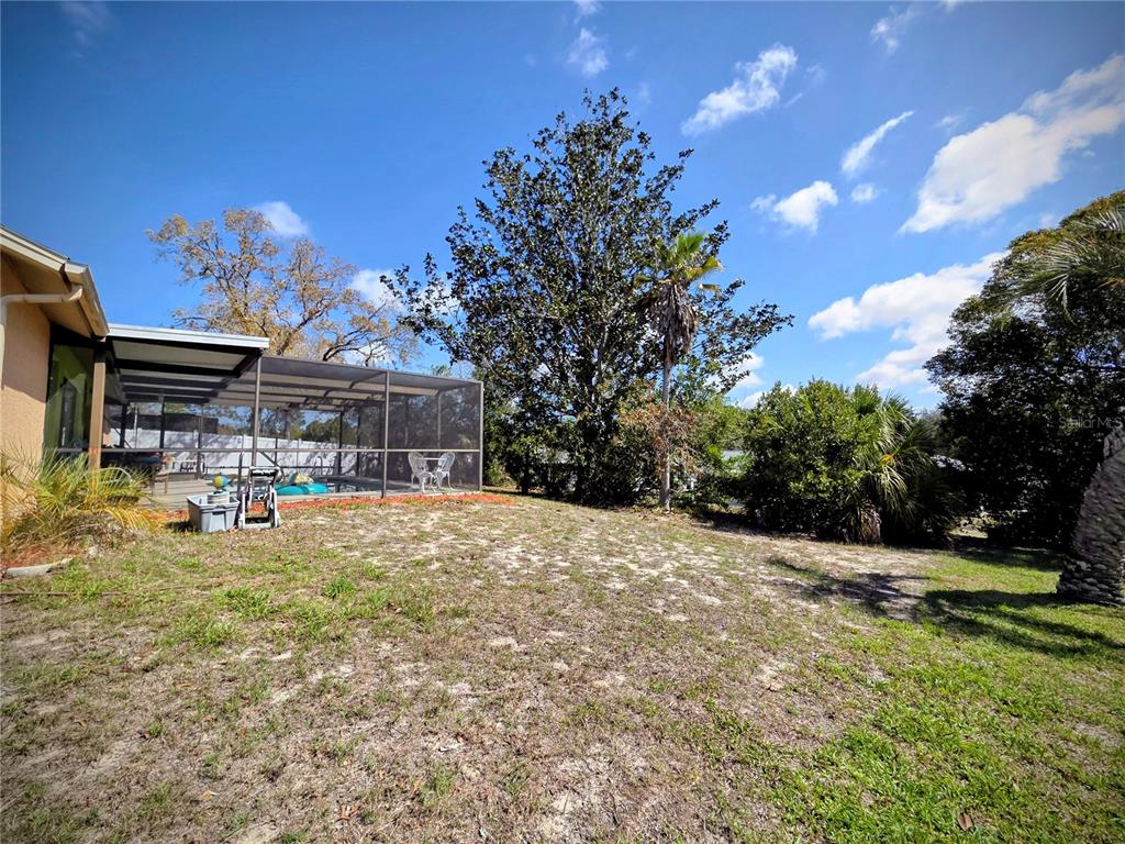 8026 Victoria Way Weeki Wachee, FL 34613 - Photo 16 of 18 a view of a yard with table and chairs under an umbrella