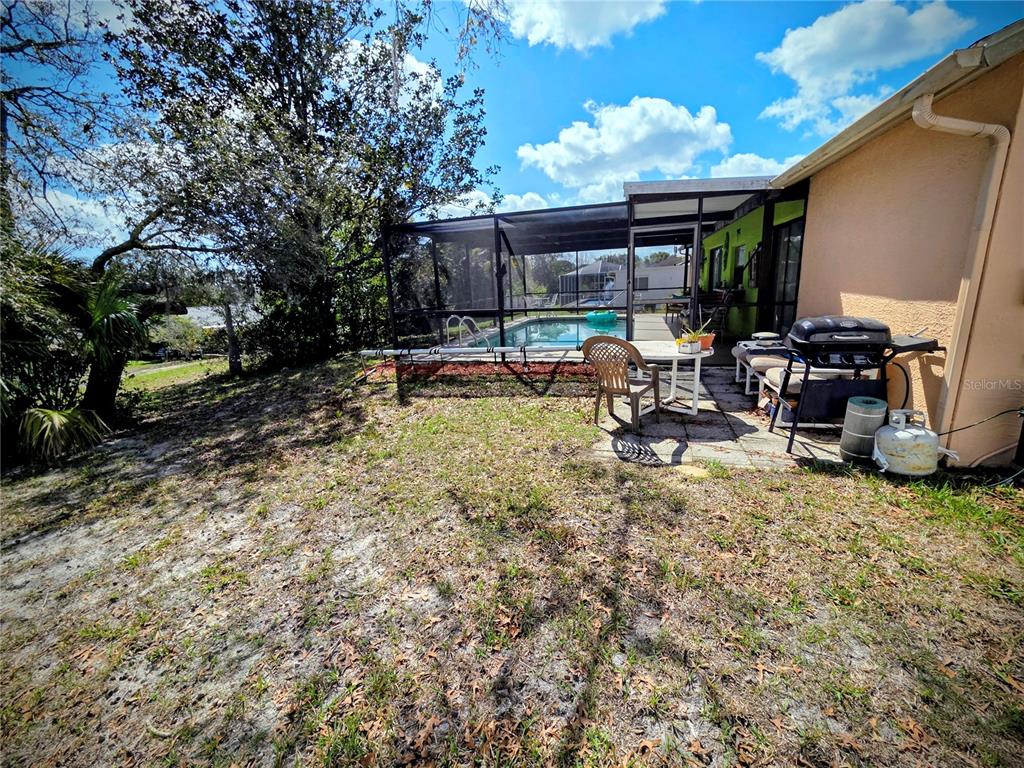 8026 Victoria Way Weeki Wachee, FL 34613 - Photo 6 of 18 a view of a patio with table and chairs under an umbrella