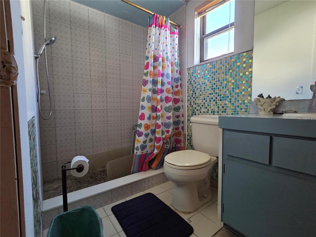 8026 Victoria Way Weeki Wachee, FL 34613 - Photo 8 of 18 a bathroom with a sink a toilet and shower curtain