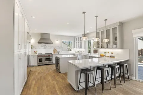 a kitchen with white cabinets and stainless steel appliances