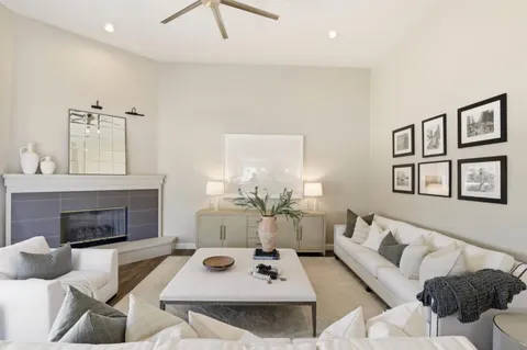 a living room with fireplace furniture and a large window