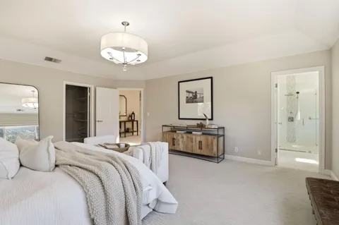 a dining hall with stainless steel appliances kitchen island granite countertop a dining table chairs and a chandelier