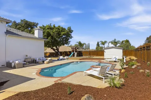 a view of a house with swimming pool and sitting area