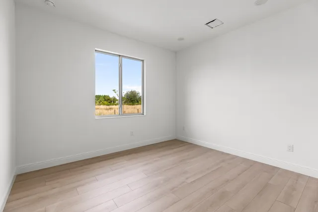 wooden floor in an empty room with a window