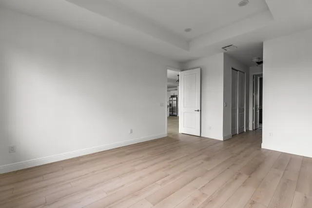 a view of an empty room with wooden floor