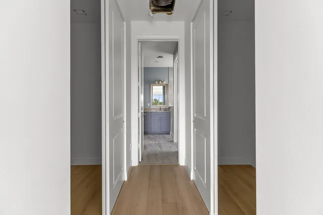 a view of a hallway with wooden floor