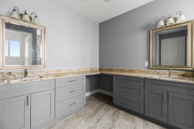 a bathroom with double sink and a mirror