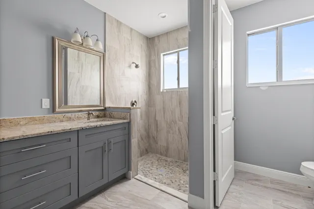 a bathroom with a granite countertop sink and a mirror