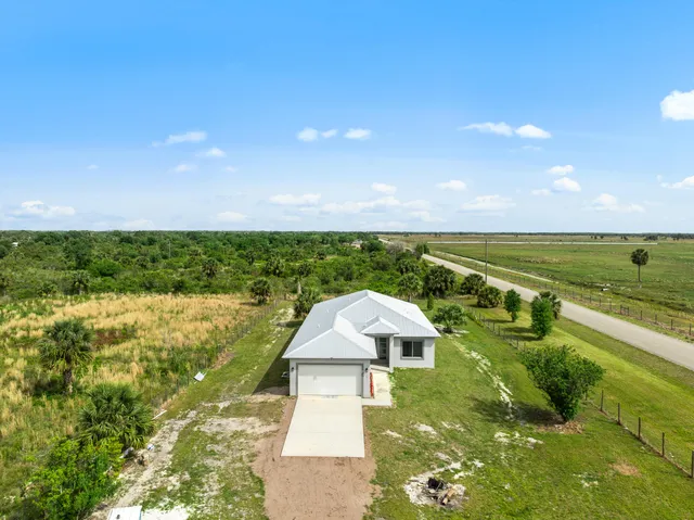 a aerial view of a house with a yard and lake view
