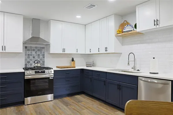 a kitchen with stainless steel appliances granite countertop a sink a stove and cabinets