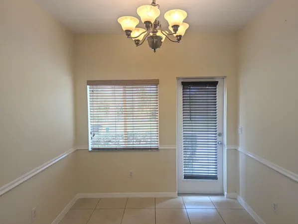 a view of a room with a chandelier fan and a window
