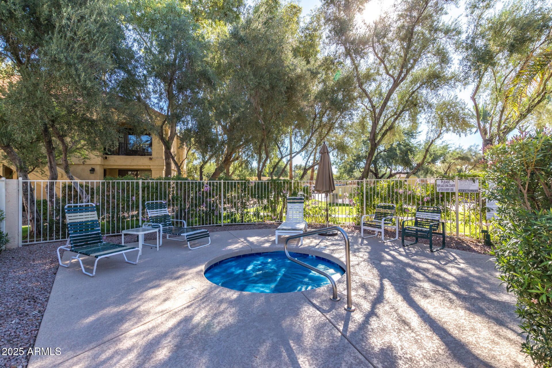 9711 East Mountain View Road, Unit 2524 Scottsdale, AZ 85258 - Photo 34 of 48 a view of a swimming pool with lawn chairs and wooden fence