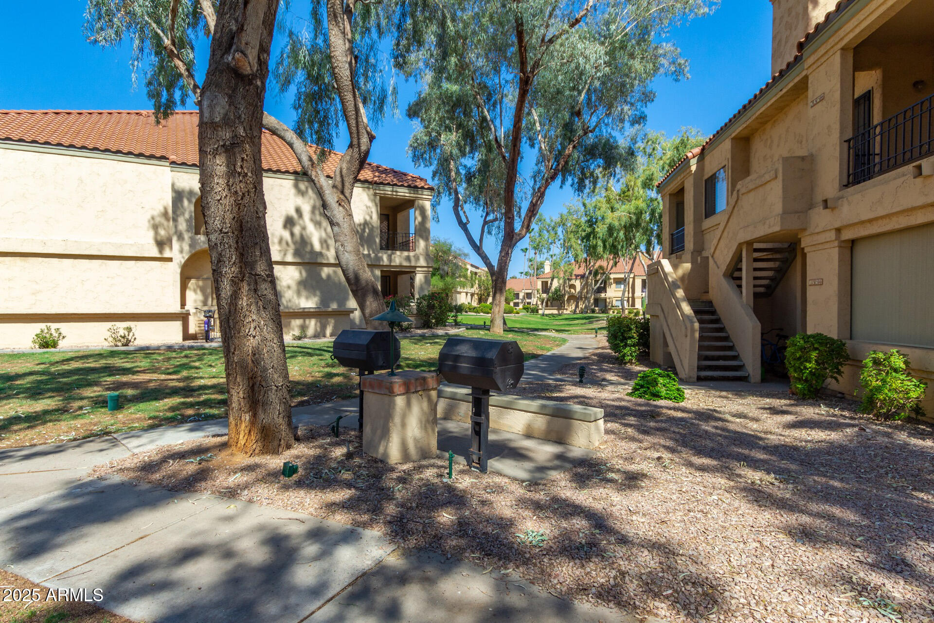 9711 East Mountain View Road, Unit 2524 Scottsdale, AZ 85258 - Photo 40 of 48 a row of table and chairs in backyard of house