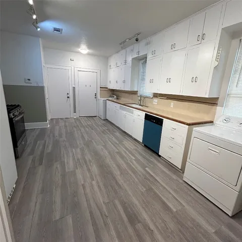 a kitchen with granite countertop white cabinets and wooden floor