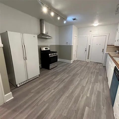 a view of kitchen with refrigerator stove and wooden floor