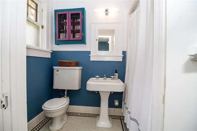 a bathroom with a toilet sink and mirror