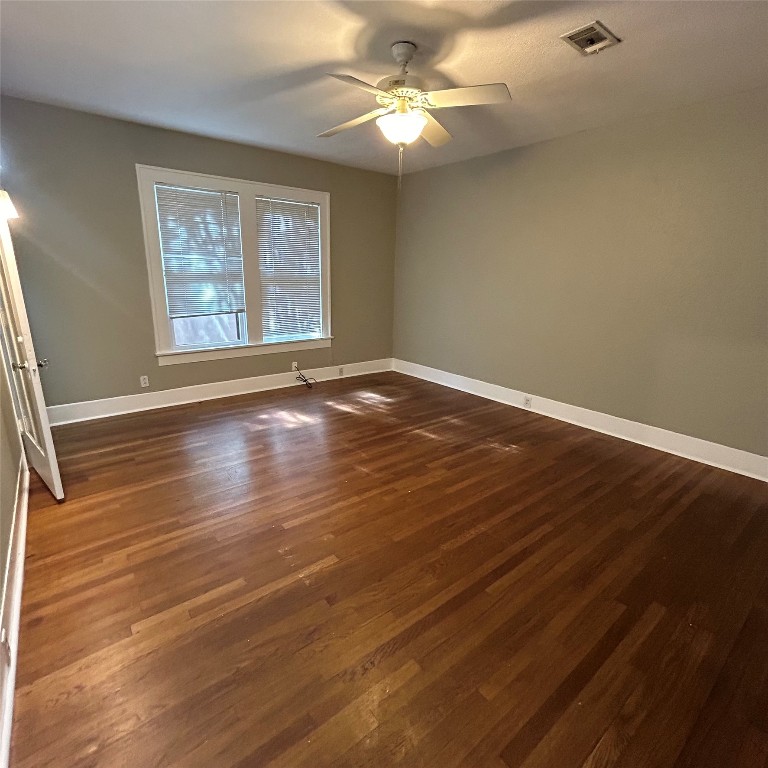 1115 West 22 1/2 Street Austin, TX 78705 - Photo 20 of 33 an empty room with wooden floor chandelier fan and windows
