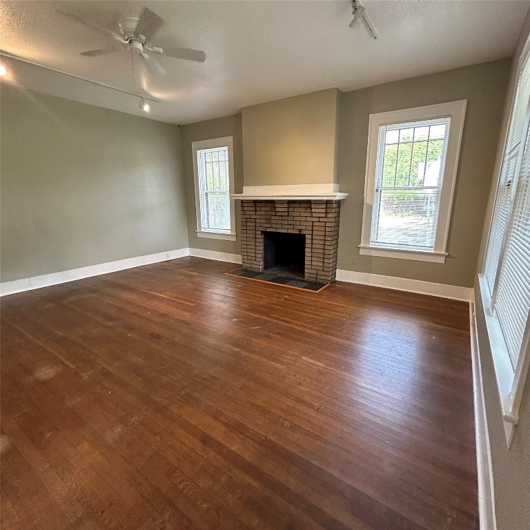 1115 West 22 1/2 Street Austin, TX 78705 - Photo 4 of 33 an empty room with wooden floor fireplace and windows