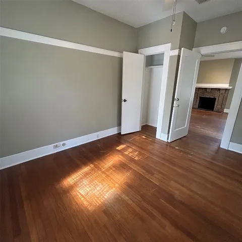 a view of empty room with wooden floor and window