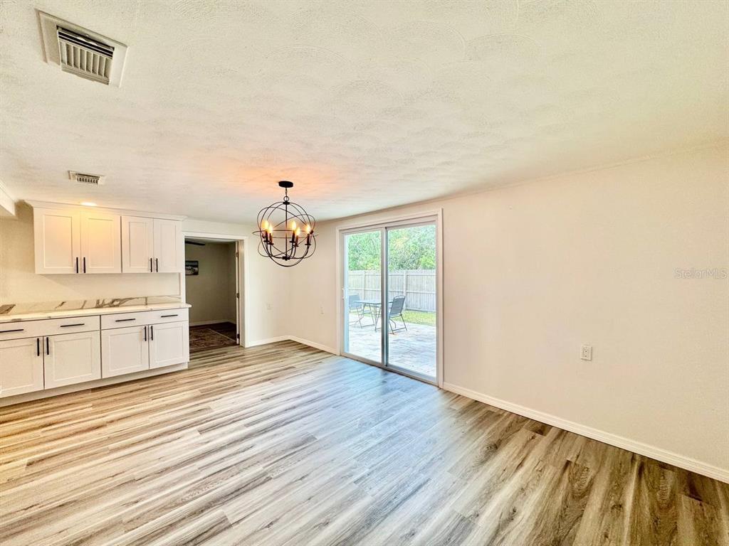 4282 Rudder Way New Port Richey, FL 34652 - Photo 27 of 34 a big room with wooden floor windows and a kitchen