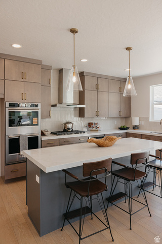 5902 Canyon Rim Road, Unit 620 Lehi, UT 84048 - Photo 5 of 78 Modern kitchen featuring an expansive center island with a light-toned countertop, wood-finish flooring, recessed lighting, and a stainless steel appliance package including a built-in oven and microwave