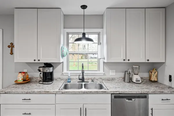 a kitchen with granite countertop white cabinets and white appliances