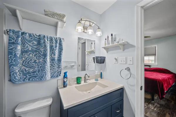 a bathroom with a sink vanity mirror and toilet