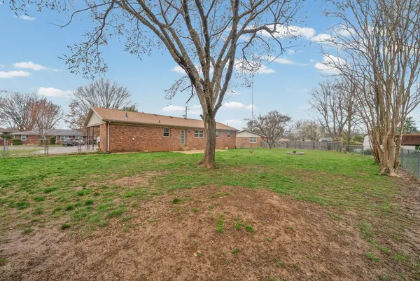a view of a house with backyard and tree s
