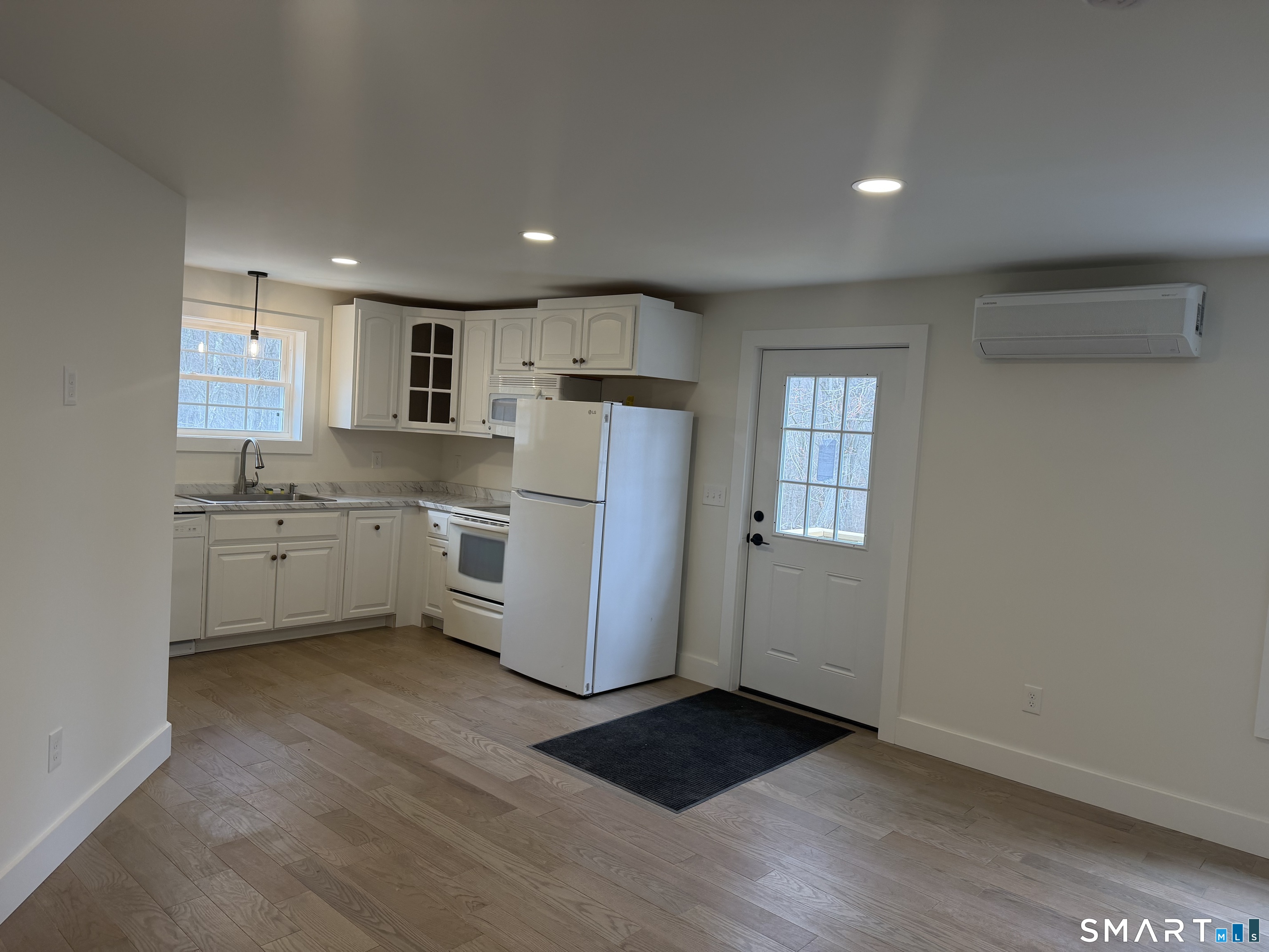 a kitchen with a refrigerator a white stove top oven and cabinets