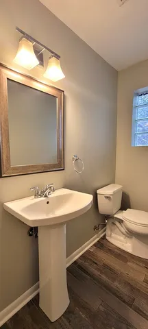 a bathroom with a toilet sink and mirror