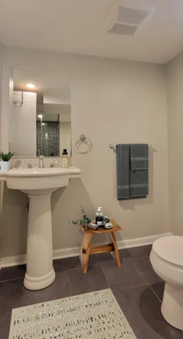 a bathroom with a sink toilet and mirror