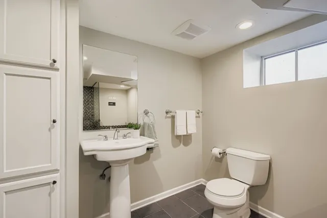 a bathroom with a sink toilet and mirror