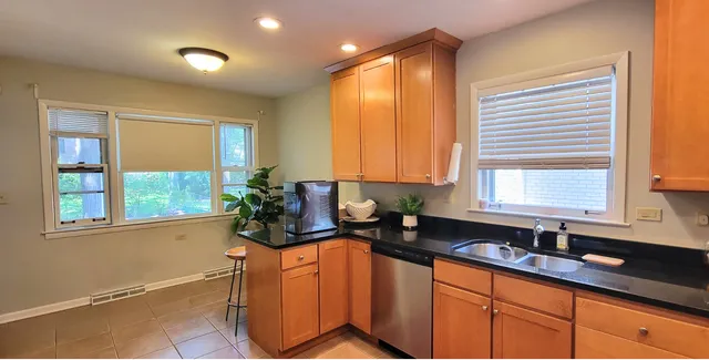 a kitchen with stainless steel appliances granite countertop sink window and cabinets