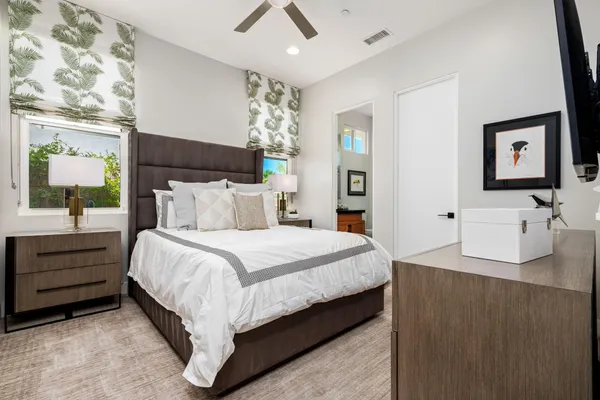 a bedroom with a bed and a flat tv screen on dresser