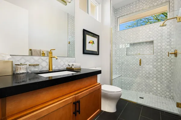 a bathroom with a sink a toilet and shower