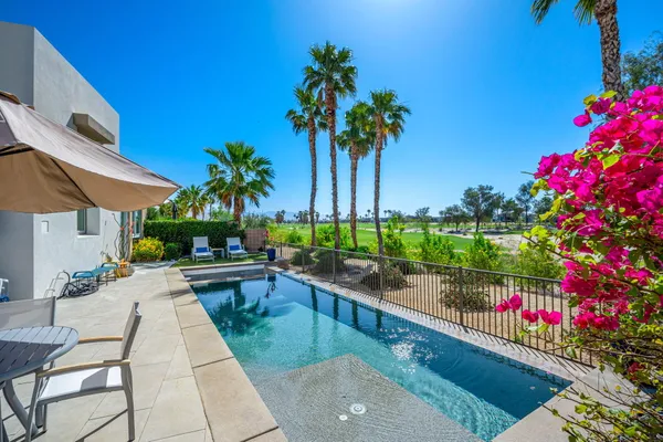 a view of a house with swimming pool and sitting area