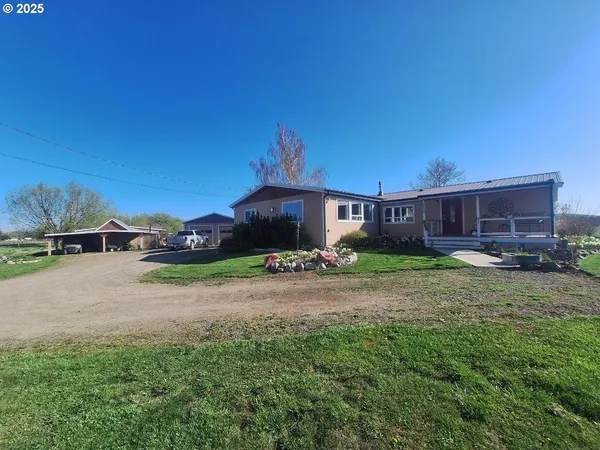 a front view of a house with yard and parking