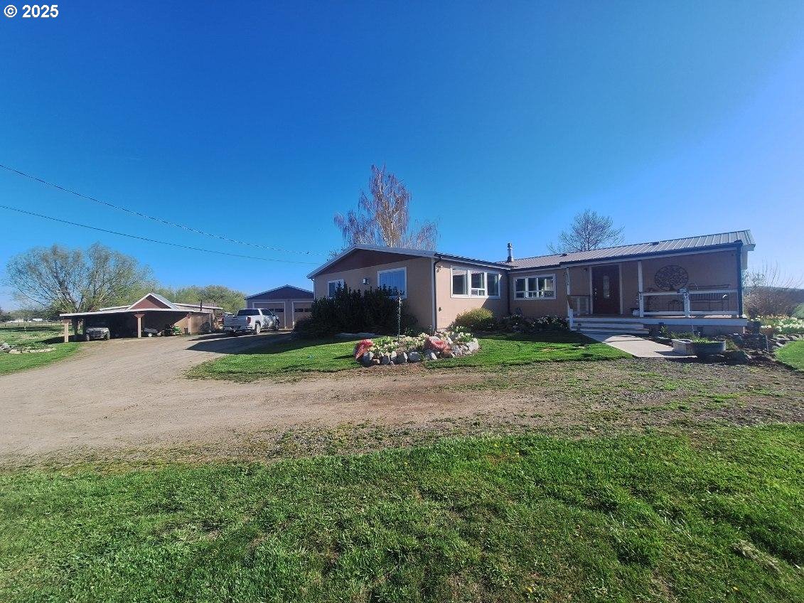 a front view of a house with yard and parking