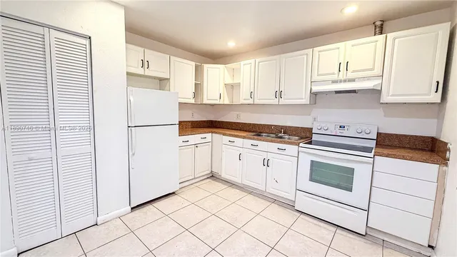 a kitchen with white cabinets and white appliances