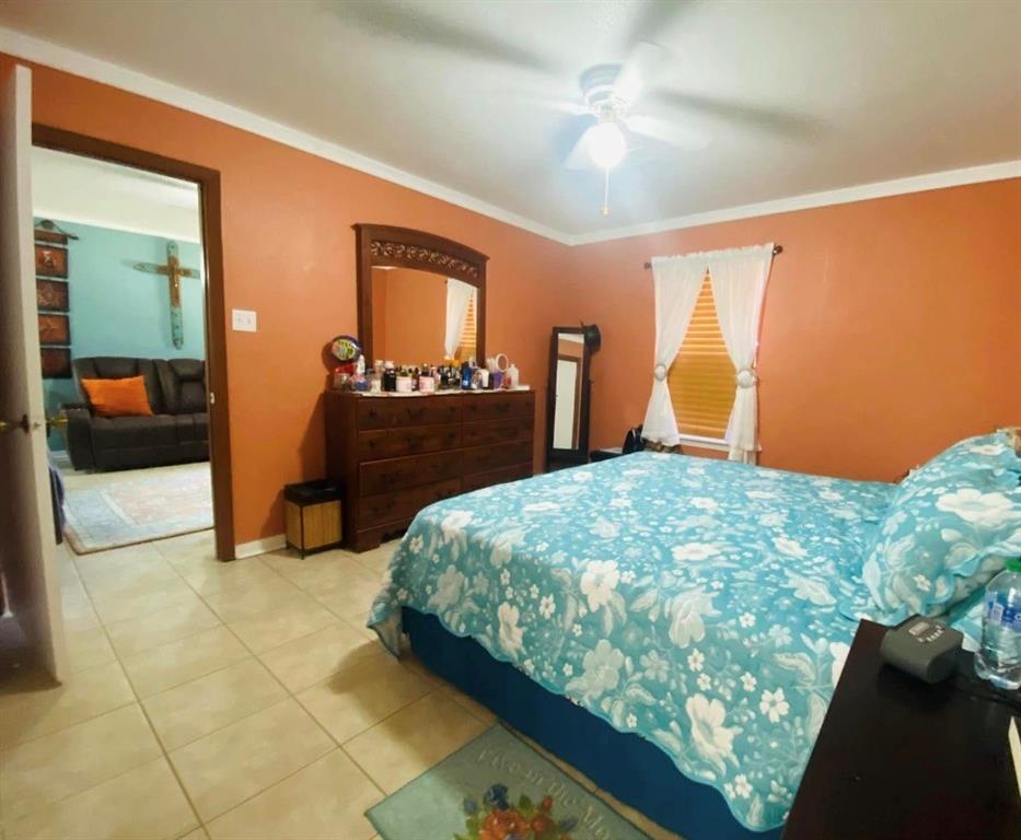 504 Wilson Road Bellmead, TX 76705 - Photo 8 of 12 Room featuring tile flooring, a window with horizontal blinds, and a ceiling fan with light fixture