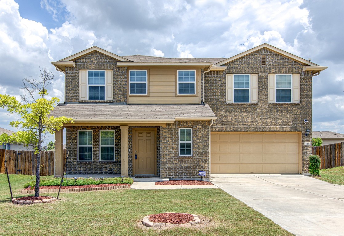 a front view of a house with a yard and garage
