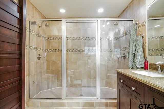 a bathroom with a shower sink and mirror