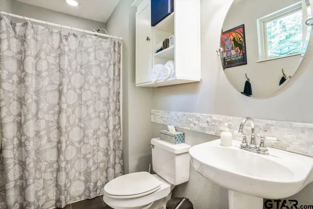 a bathroom with a toilet a sink and a mirror