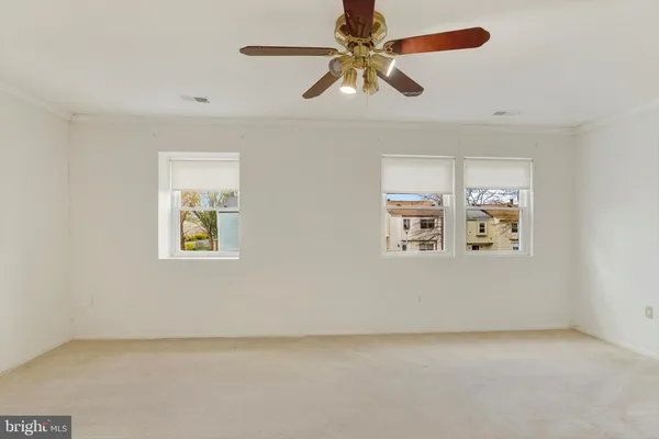 an empty room with windows and fan